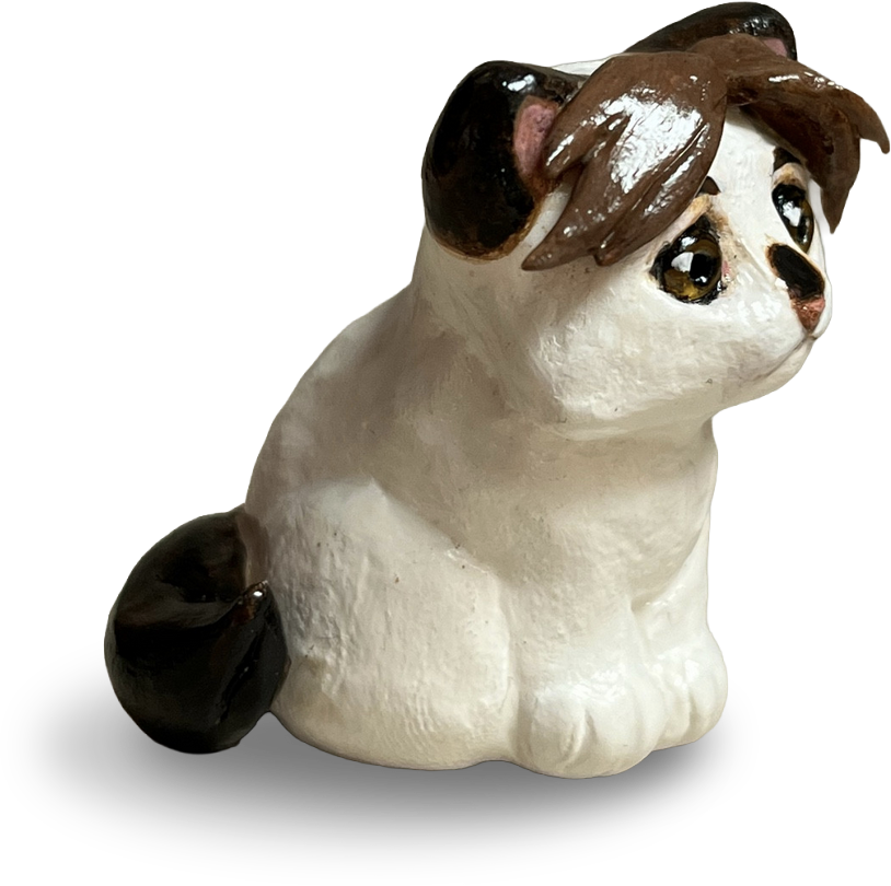 Clay figurine of a white and brown cat.